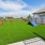 a grassy area with a fence and a building in the background