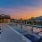 a swimming pool with lounge chairs at dusk