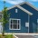 a blue house with a parking lot